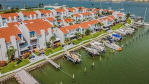 A marina with boats docked, a waterfront property with buildings, and a clear view of the water. - Madeira Beach Yacht Club! Steps to Beach Access! (North Redington Beach)