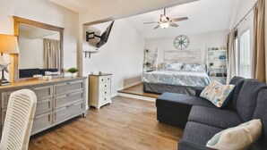 A bedroom with a bed, a desk, a chair, a dresser, a ceiling fan, and a window with curtains. - Madeira Beach Yacht Club! Steps to Beach Access! (North Redington Beach)