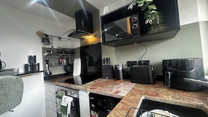 A compact kitchen with a microwave, toaster, and coffee maker. - Comfortable 1-bed Chester Apartment with Parking & Full Kitchen, Home from Home (Chester)