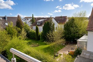 Una zona residencial con casas, un jardín bien cuidado y cielo despejado.