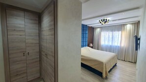 Ein Schlafzimmer mit Bett, Kleiderschrank und Deckenleuchte.