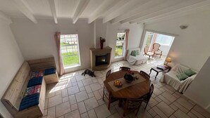 Una habitación amplia con chimenea, una mesa de comedor con sillas, un banco y un sofá.