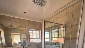 Baño con inodoro, lavamanos, bañera y zona de ducha.