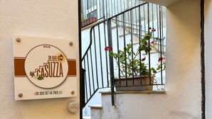 A door with a sign indicating a B&B named 'Di Giù Ghi Casuza' with a phone number. - At Casuzza di Giù Giù: Experience your stay in the historic center of Agrigento! (Agrigento)