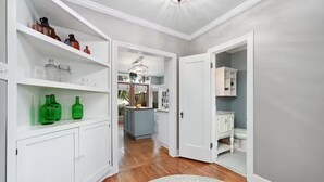 A hallway with white cabinetry, a wooden floor, and a patterned rug. - Park Free  Walk to SoCo  Ride to DT/UT/COTA (Austin)
