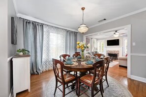 A dining area with a round table, chairs, and a chandelier. - Park Free Walk to SoCo Ride to DT/UT/COTA (Austin)