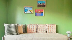 A room with a bed, green walls, and two framed pictures. - Studio St Gilles X Vie between beach, town and port. (Saint-Gilles-Croix-de-Vie)