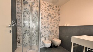 Ein Badezimmer mit Duschkabine, Toilette und Waschbecken.