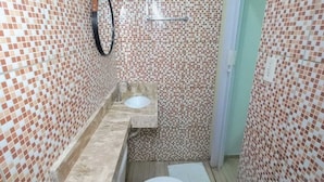 A small bathroom with a toilet, sink, and shower. - Pousada Aconchego em Mundaú (Trairi)