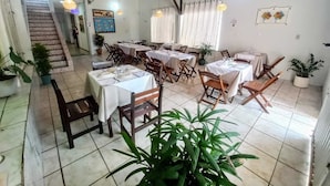 A restaurant with multiple tables and chairs, a staircase, and potted plants. - Pousada Aconchego em Mundaú (Trairi)