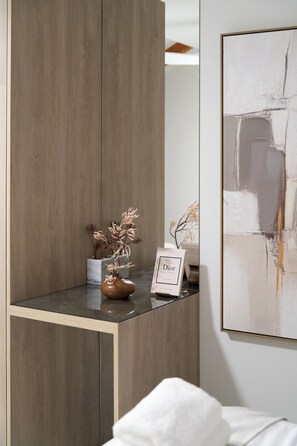 A modern room with a wooden cabinet, a vase with dried flowers, a framed picture, and a large abstract painting on the wall. - Spacious Family Duplex- The Shouk House (Jerusalem)