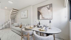 A modern dining area with a round table, chairs, and a staircase in the background. - Spacious Family Duplex- The Shouk House (Jerusalem)