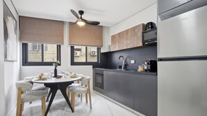 A modern kitchen with a dining area, a ceiling fan, and a view through the window. - Spacious Family Duplex- The Shouk House (Jerusalem)