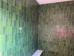 A room with green tiled walls and a white bench. - Coming Soon!! Immersive Giraffe experience in our rustic luxurious condo. (Lometa)