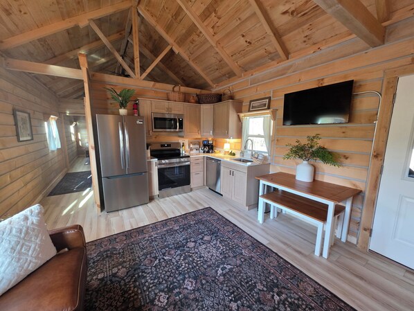 A compact kitchen with a refrigerator, microwave, oven, and sink.