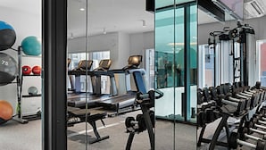 Et fitnesscenter med løbebånd, styrkemaskiner og træningsbolde.