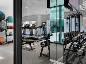 Ein Fitnessstudio mit Laufbändern, Kraftgeräten und Trainingsbällen.