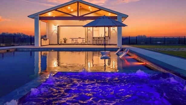 A pool with a hot tub and a covered seating area with a view of the sunset. - Modern Luxury Retreat w/ Pool, Spa & Sunset Views (Wallkill)