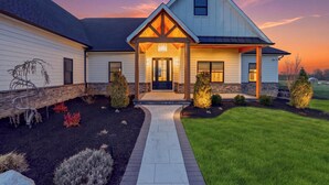 A modern house with a covered porch, a well-maintained lawn, and a driveway. - Modern Luxury Retreat w/ Pool, Spa & Sunset Views (Wallkill)