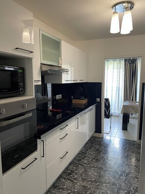 A modern kitchen with a microwave, oven, and black countertop. - Oriental escape in the heart of Fort-de-France (Fort-de-France)