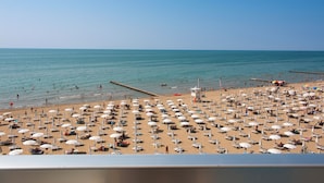 Une plage avec de nombreux parasols et des chaises longues.