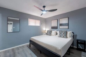 A bedroom with a bed, a ceiling fan, a window, a mirror, and two framed pictures on the wall. - 1BR/1BA Chic Home • King Bed • Smart TV’s (El Paso)