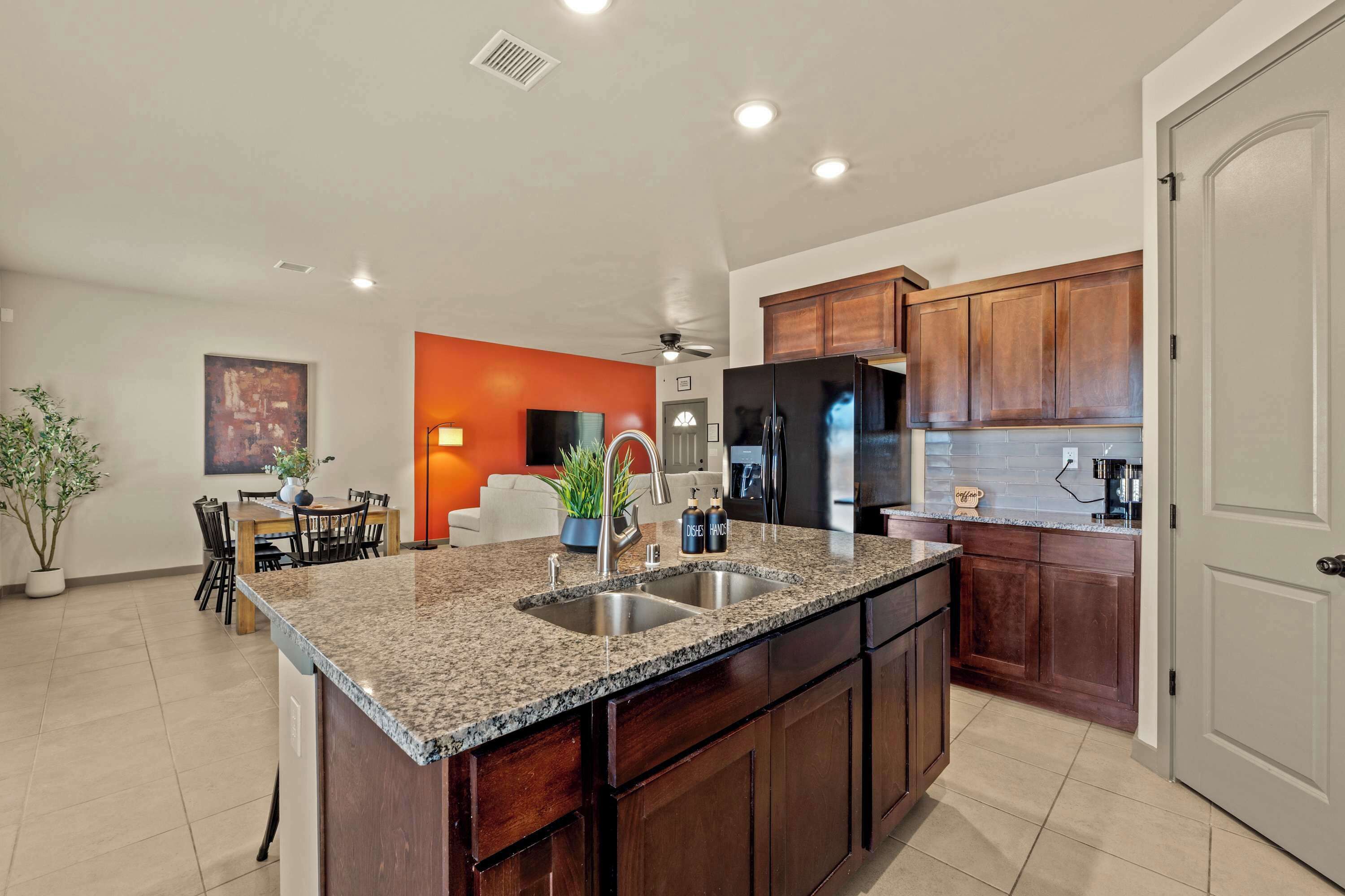 A modern kitchen with granite countertops, stainless steel appliances, and wooden cabinets.
