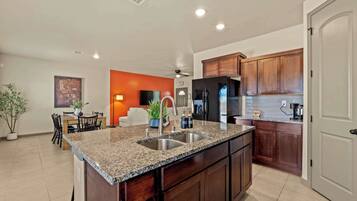A modern kitchen with granite countertops, stainless steel appliances, and wooden cabinets.