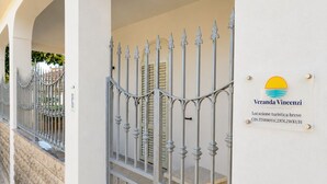 Una entrada con puerta y un letrero que dice 'Veranda Vincenzi' y una breve descripción del lugar tur ístico.