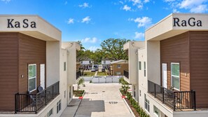 A modern building with 'KaSa' and 'RaGa' signs, a central courtyard, and a clear sky. - Ultimate Tampa Stay | Dual Units • 6BR • Sleeps 17 (Tampa)