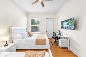 A bedroom with a bed, desk, chair, and a television. - Ultimate Tampa Stay | Dual Units • 6BR • Sleeps 17 (Tampa)