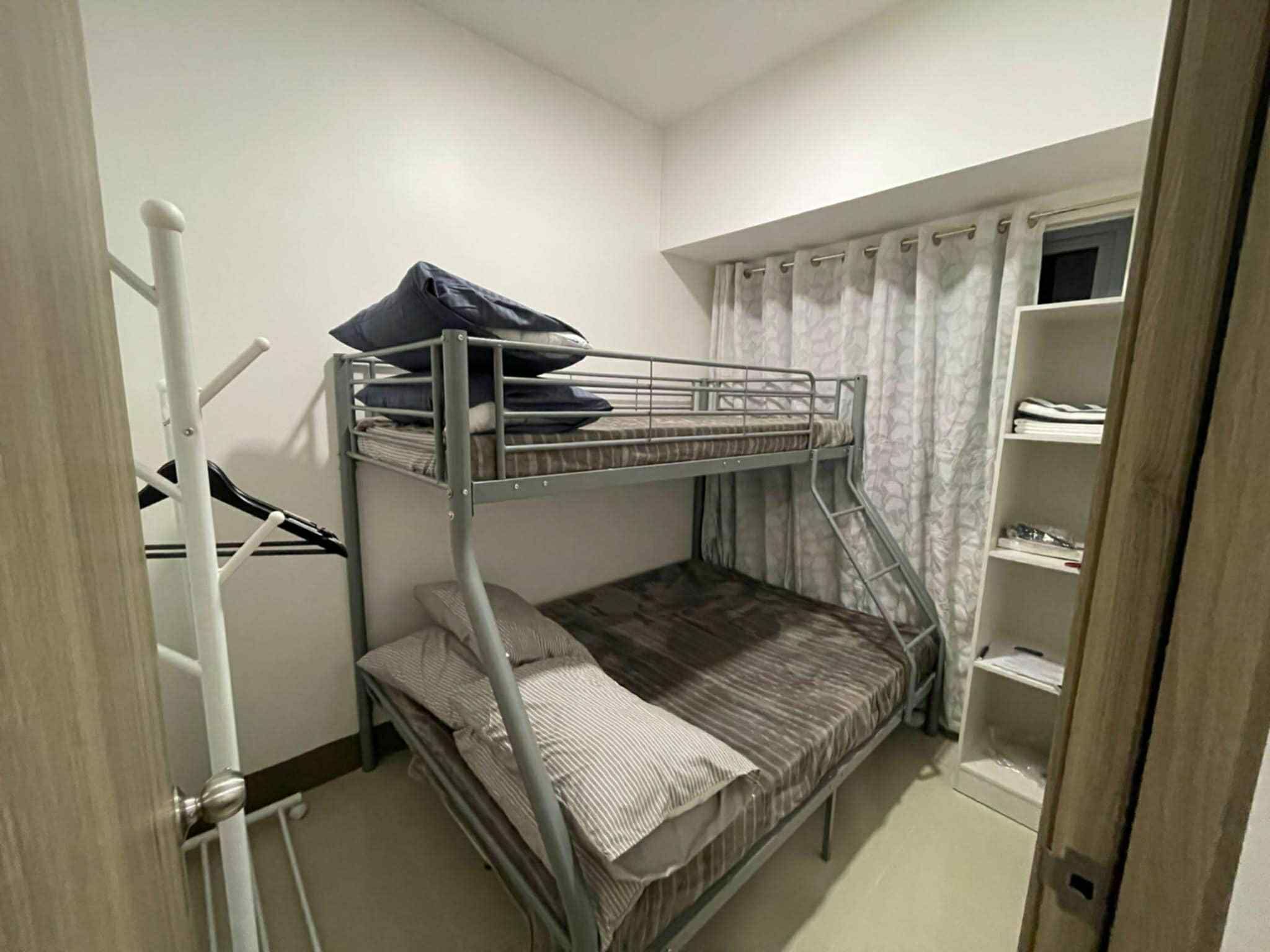 Habitación con literas, armario y estantería.