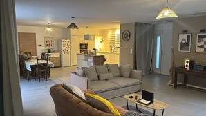 Ein modernes Wohnzimmer mit einer Couch, einem Couchtisch und einem Essbereich mit Stühlen und einem Tisch.