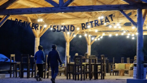 Un pabellón de madera con un letrero que dice 'Beaver Island Retreat' y guirnaldas de luces.