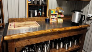 Una cocina con encimera de madera, cafetera y diversos utensilios.