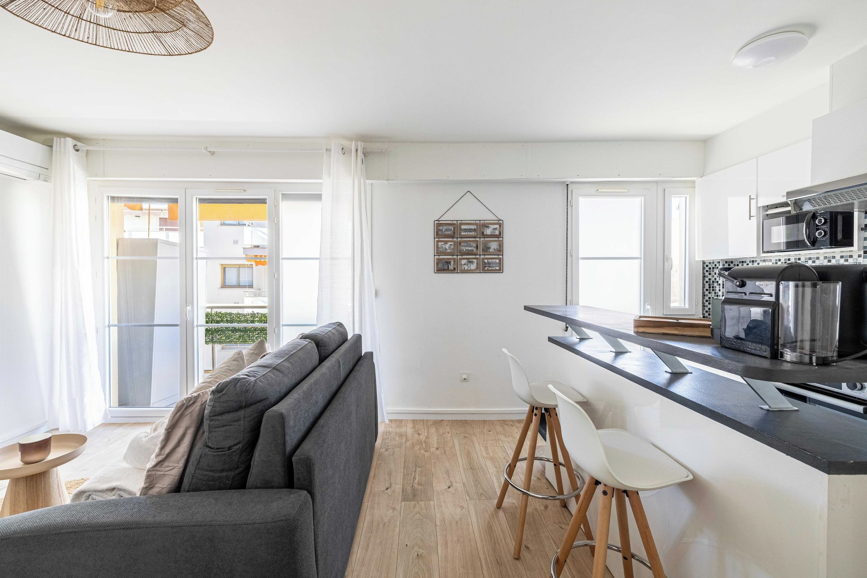 A modern kitchen with a black countertop, white cabinets, and a built-in espresso machine.