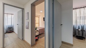 A hotel room with a bed, a desk, and a chair. There is a door leading to another room. - Perfect 3-bedroom apartment in Medellín for a relaxing stay (Medellín)