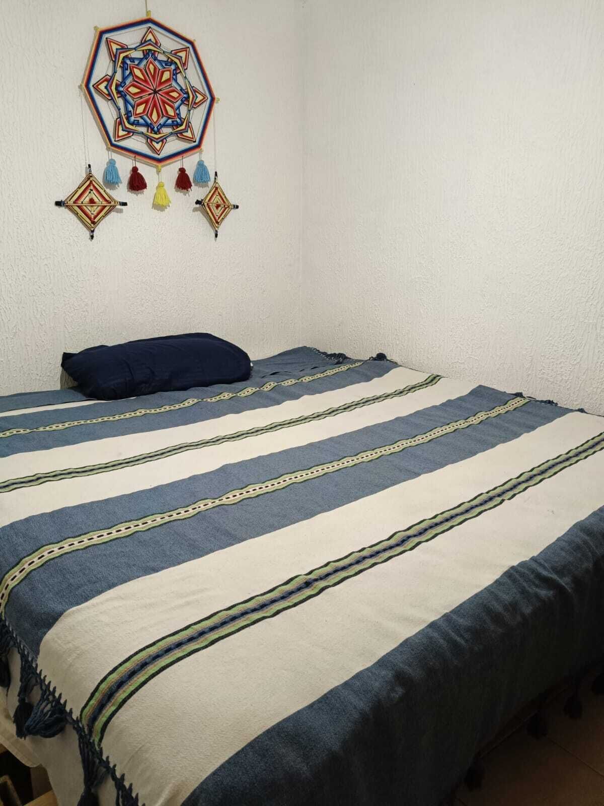 Ein Zimmer mit einem Bett, einer Wanddekoration und einem Fenster.