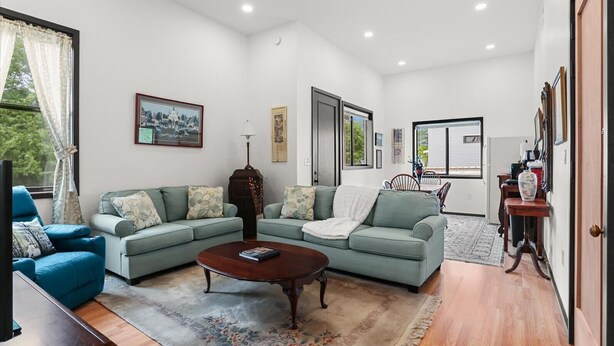 A living room with a sectional sofa, a coffee table, and a dining area with a table and chairs. - Riverside Retreat! Quiet and Charming 2 bed/2 bath (New Orleans)