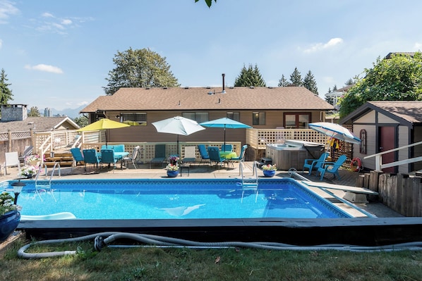 Un jardin avec une piscine, du mobilier d’extérieur et un jacuzzi.