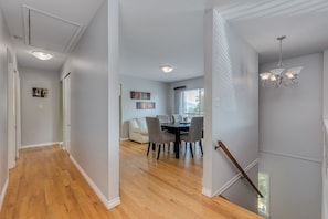 Un intérieur moderne comprenant un coin repas, un escalier et un couloir.