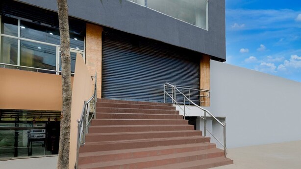 A modern building with a staircase leading to a garage door. - Deluxe Hotel Santosh Palace (Prayagraj)