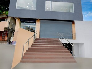 A modern building with a staircase leading to a garage door.
