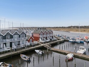 En ejendom ved vandet med flere træhuse, en anløbsbro og adskillige både.