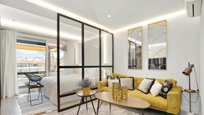A modern hotel room with a large bed, a yellow sofa, a coffee table, and a balcony with a view. - Golden Mile Lux Sea View Suite & Balcony (Marbella)