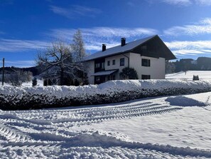 A two-story house with a snow-covered roof and a clear blue sky. - Waldesruh - Nature & Relaxation in the Allgäu (Grünenbach)