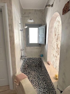 A bathroom with a tiled floor, a shower, a window with a view, and a towel rack. - Villa Thea (Episkopi Gonias)