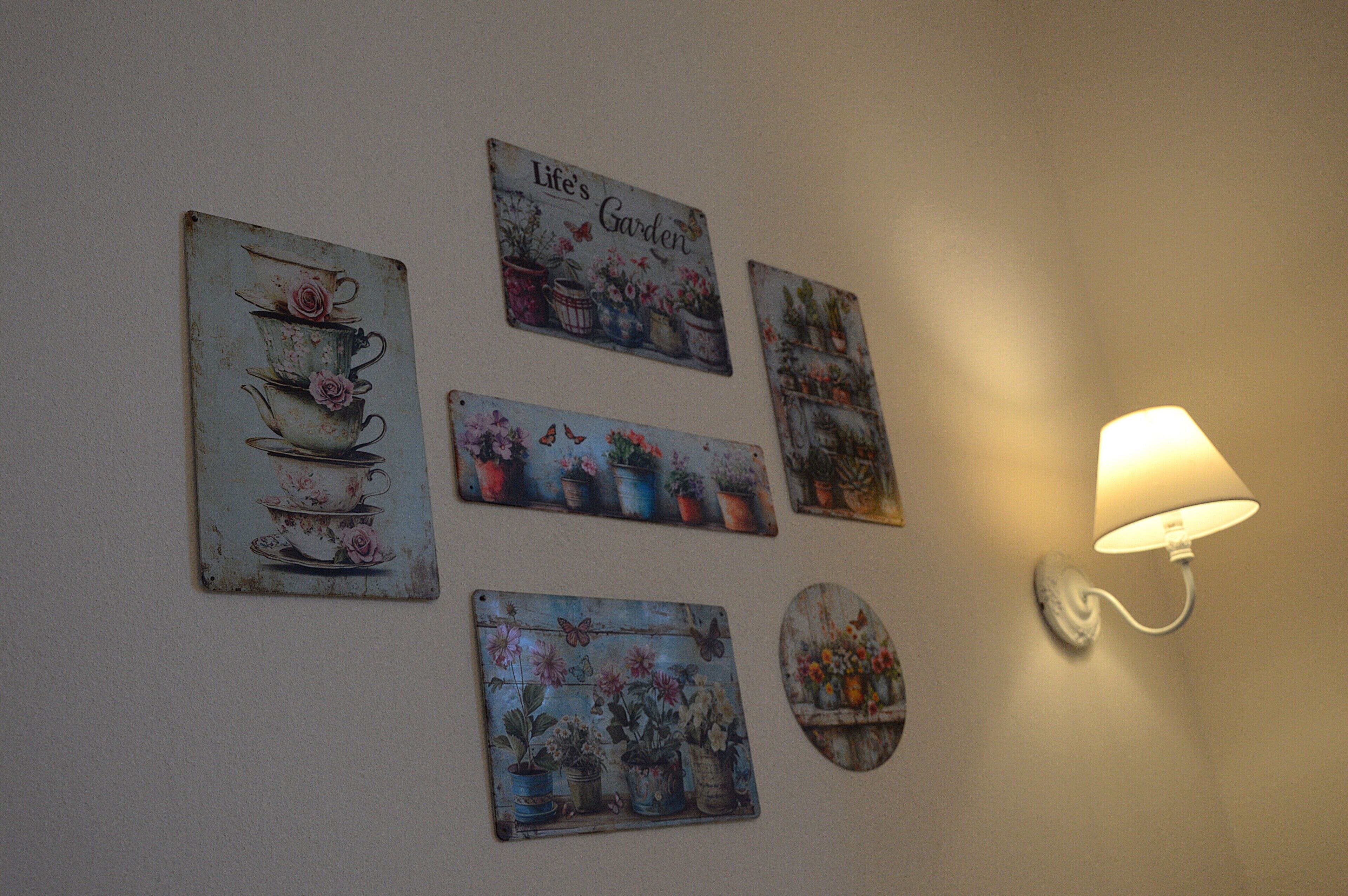 A wall with various metal signs and a wall-mounted lamp.