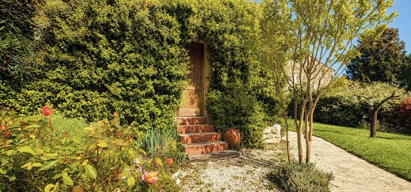 A garden with a brick structure, a pathway, and lush greenery. - Villa with private pool between Nîmes and Uzès (Saint-Mamert-du-Gard)