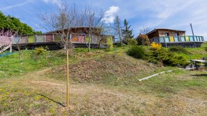 A hillside with two wooden houses, one with a balcony and a small shed. - Small cottage in the heart of Beaujolais (Rivolet)